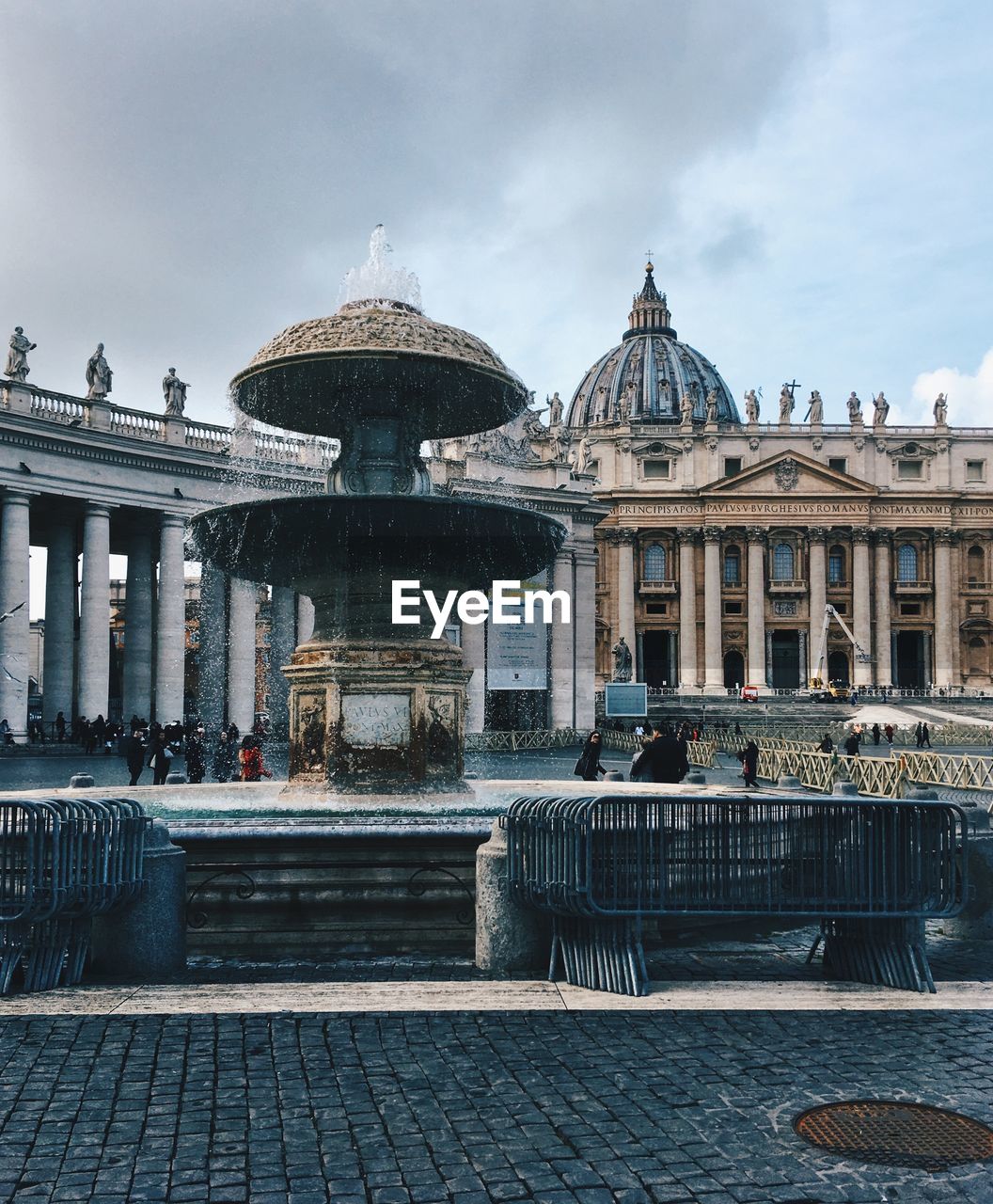 Fountain against historic buildings in city