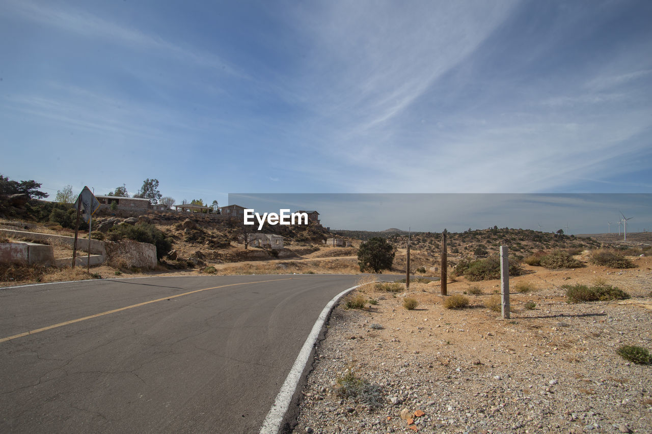 Empty road along landscape against sky