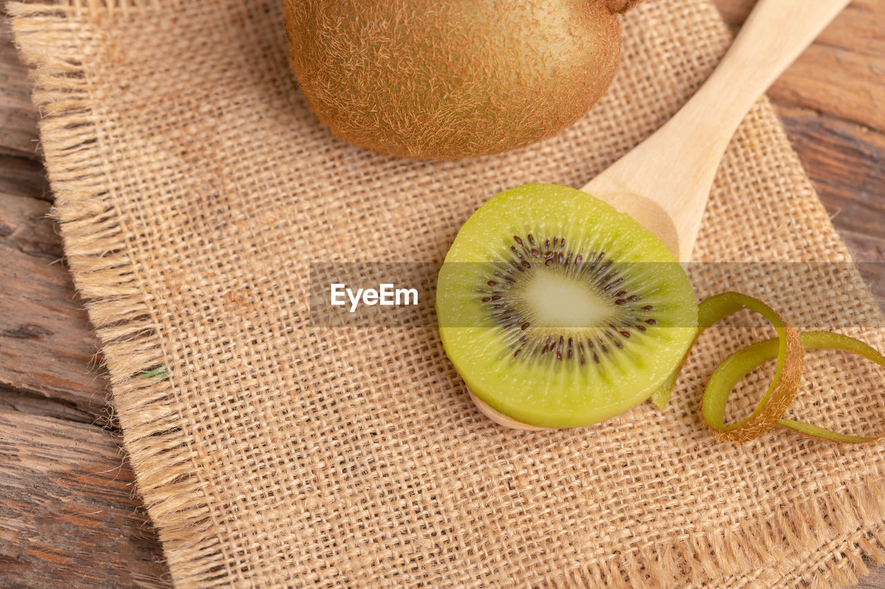 Top view of a kiwi slice placed on the wood spoon