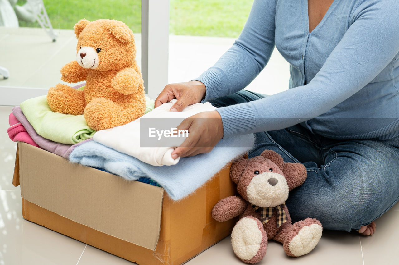 midsection of woman with teddy bear