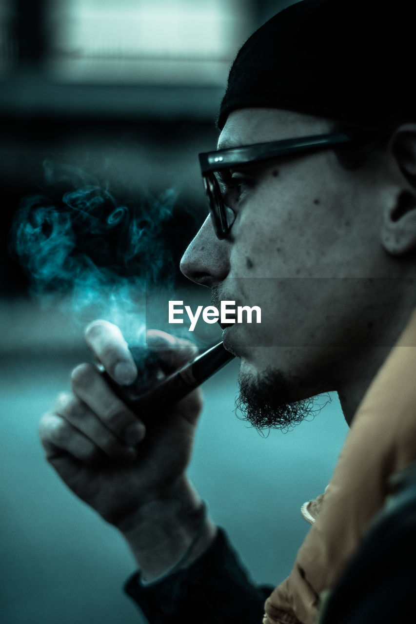 Cropped image of man smoking pipe