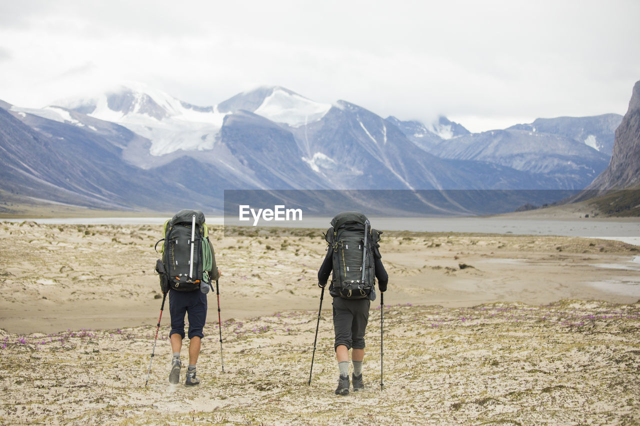 Two backpackers hiking in auyuittuq national park, canada.