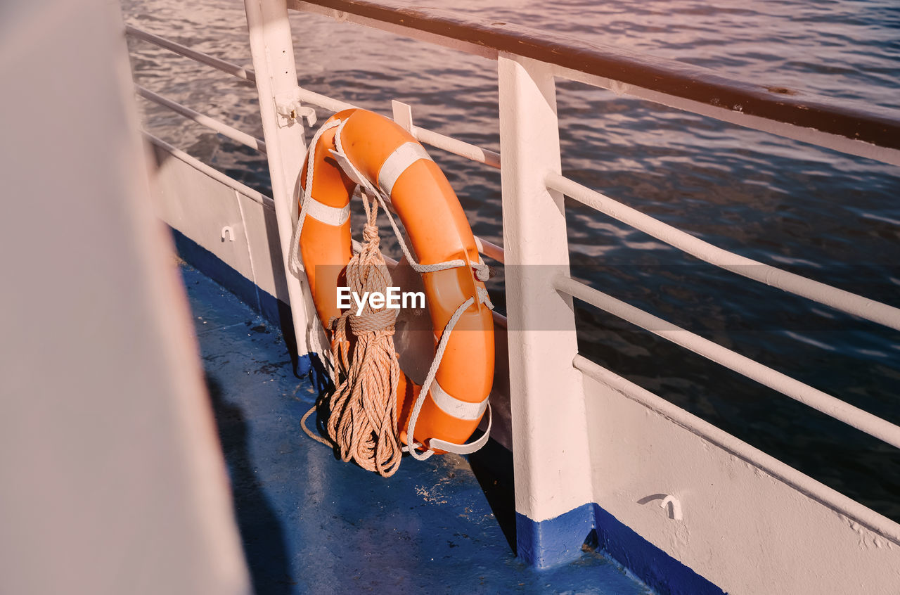 High angle view of lifebelt tied to railing of boat