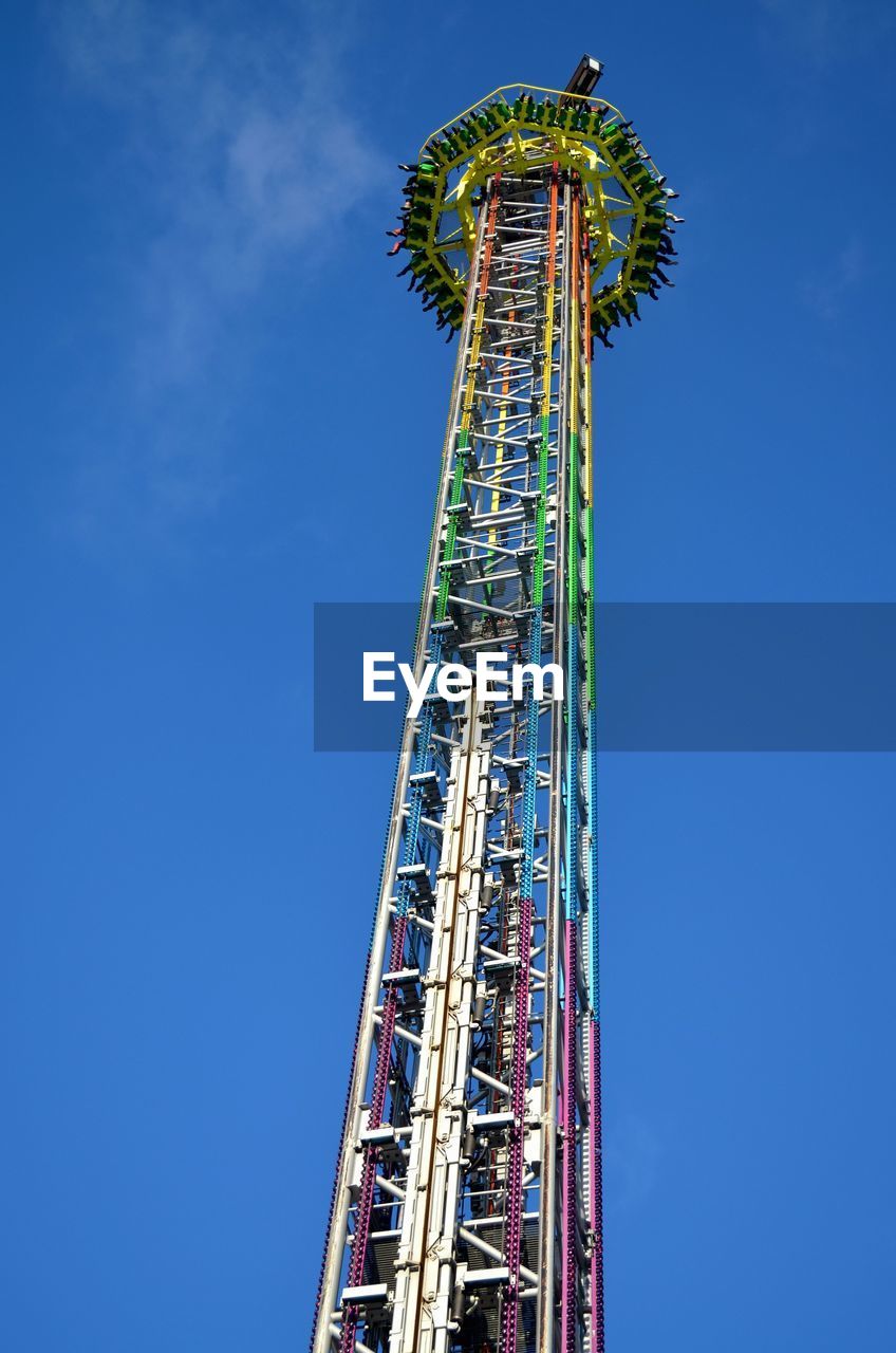 Low angle view of drop tower against blue sky