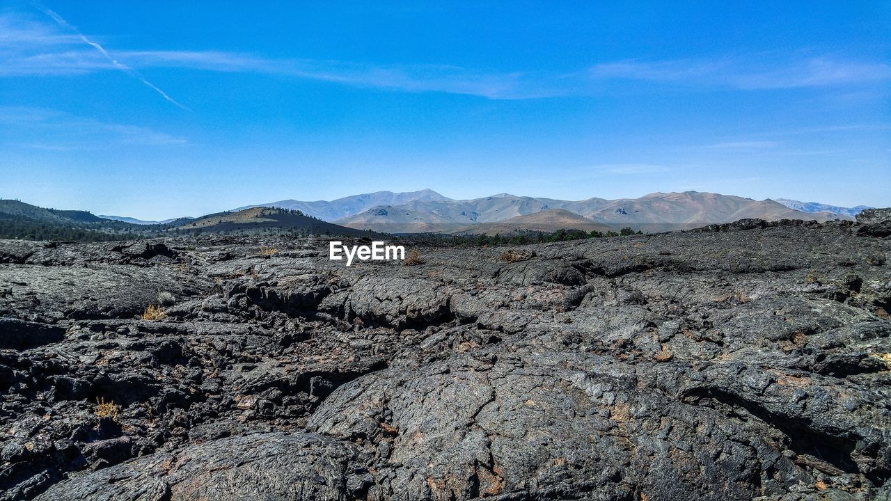 Scenic view of dramatic landscape against blue sky