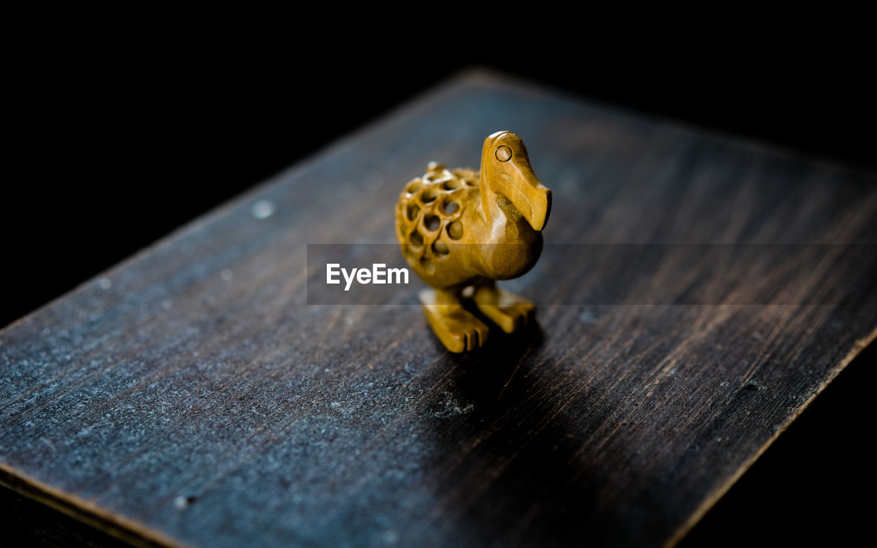 Close up of a dodo bird wood carving on a wooden table