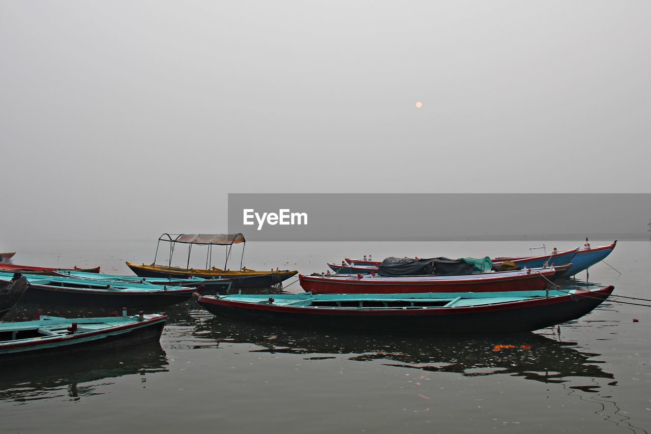 BOATS MOORED ON HARBOR AGAINST CLEAR SKY