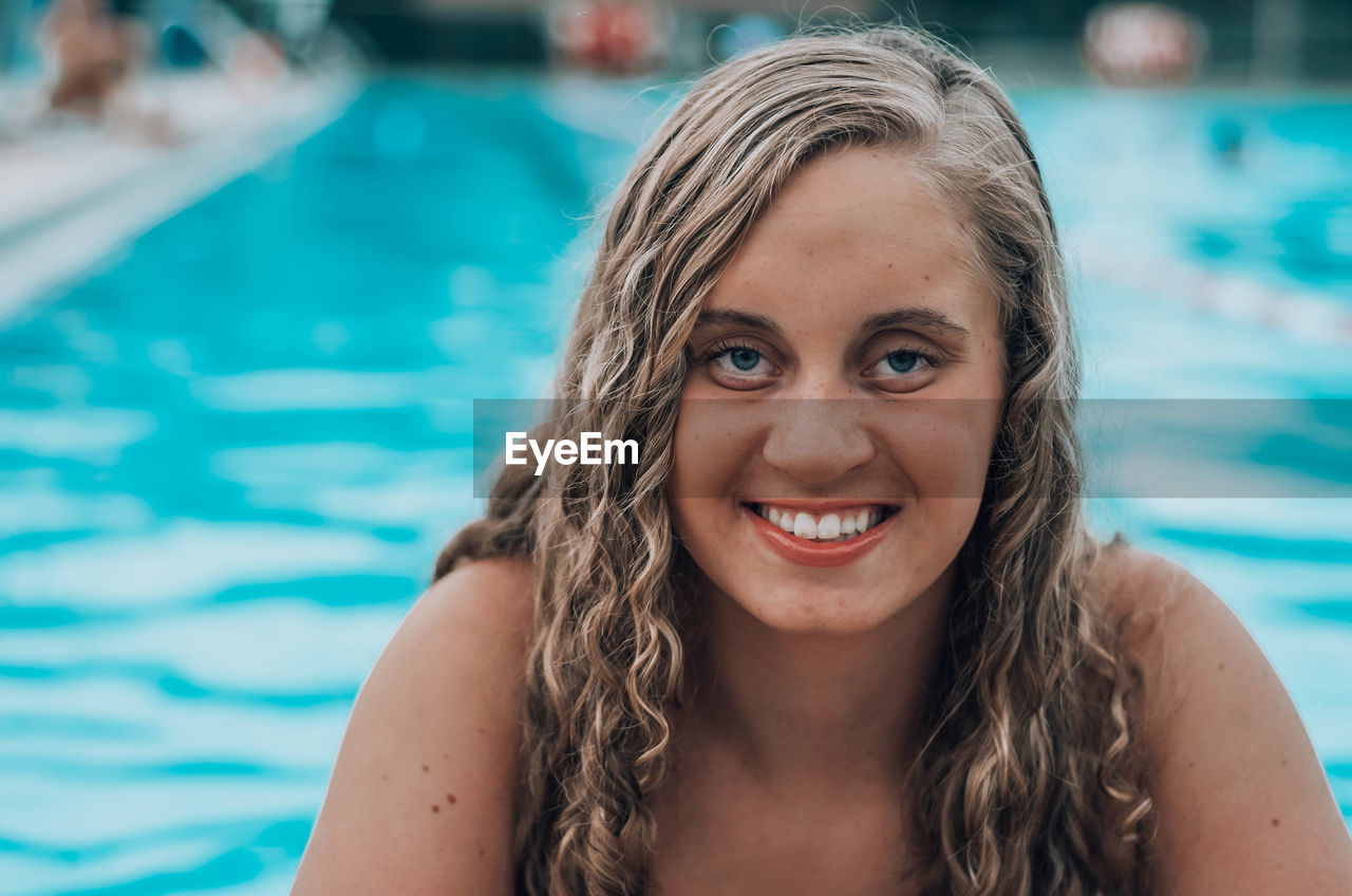 Portrait of smiling young woman in swimming in pool