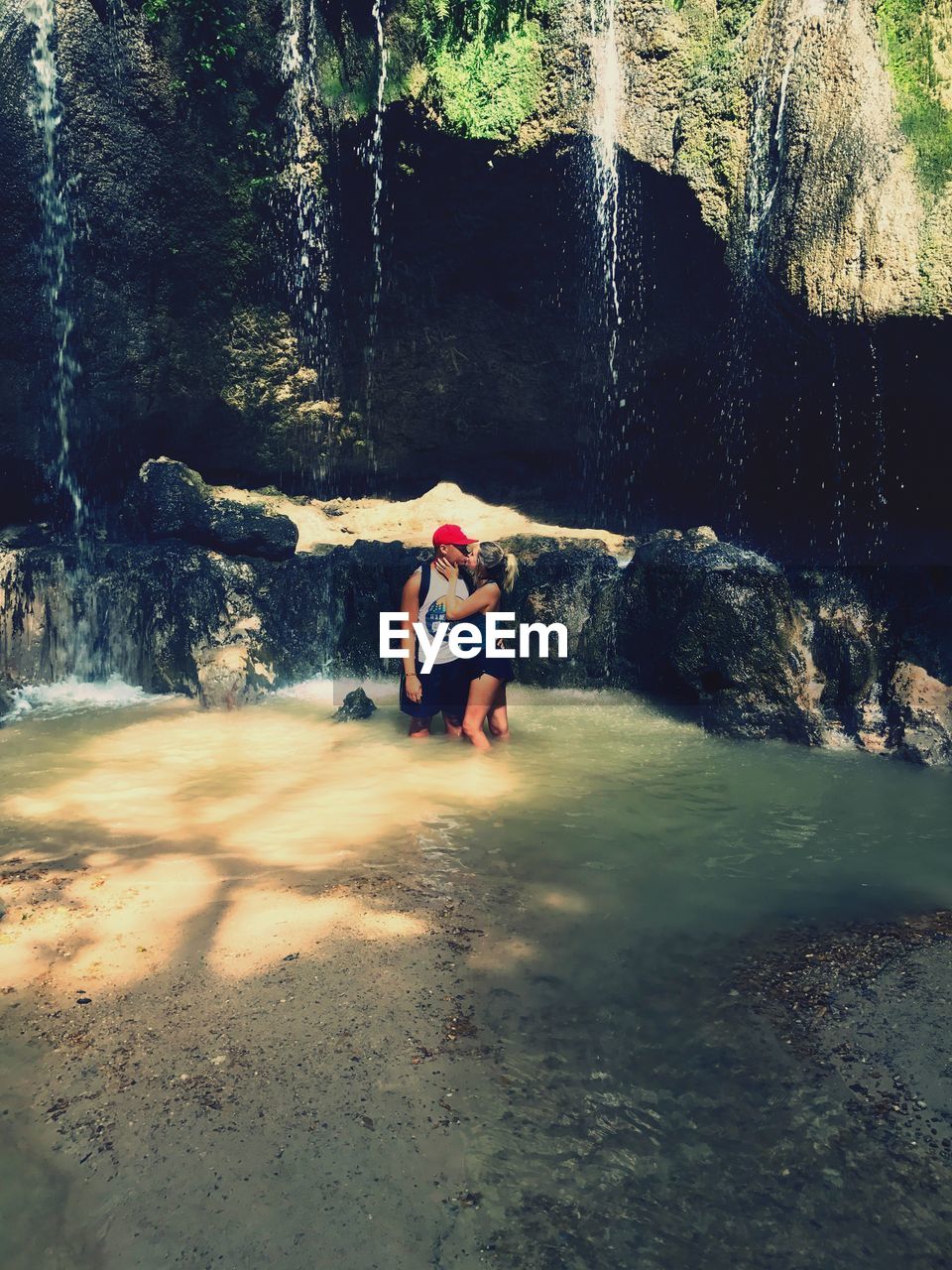 BOY SITTING ON ROCK AT FOREST