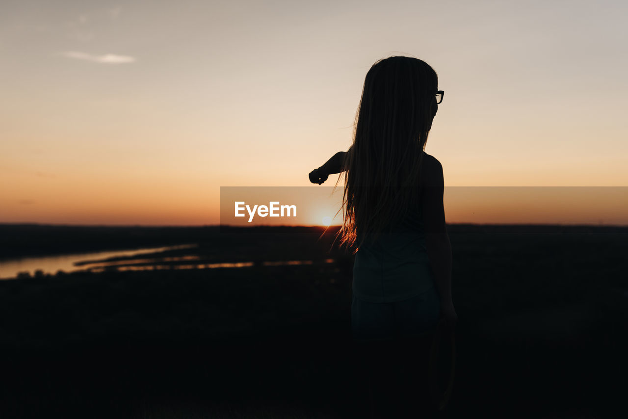 Little girl watches sunset overlooking missouri river in bismarck north dakota