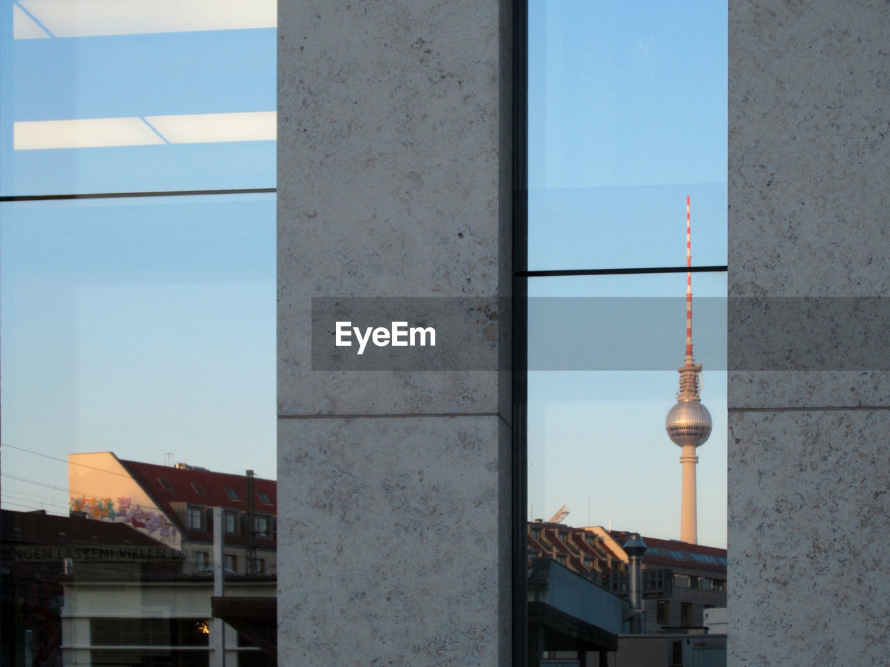 Reflection of fernsehturm on glass window of building