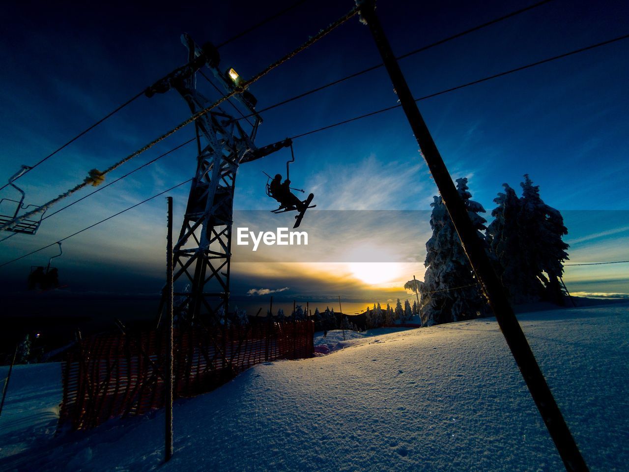 Silhouette ski lift against sky during winter