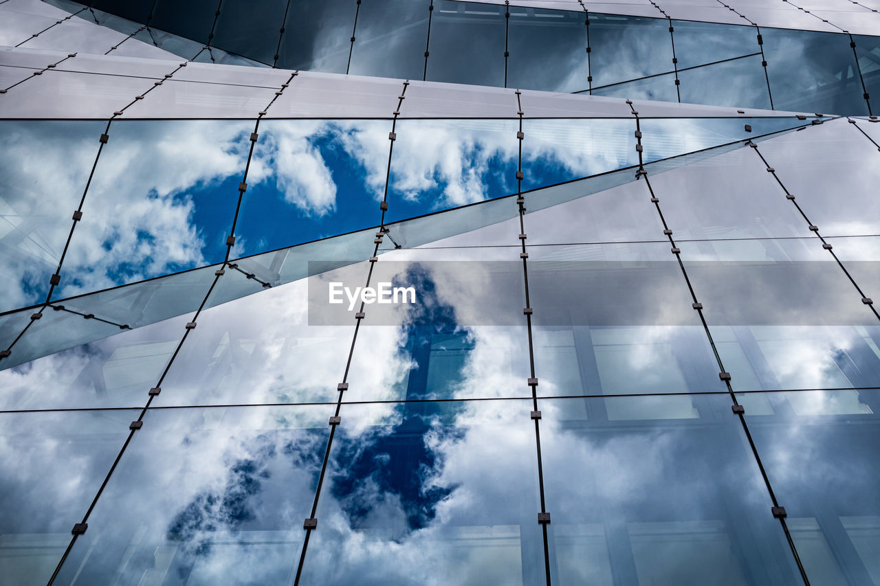 Glass building with reflection of cloudy sky