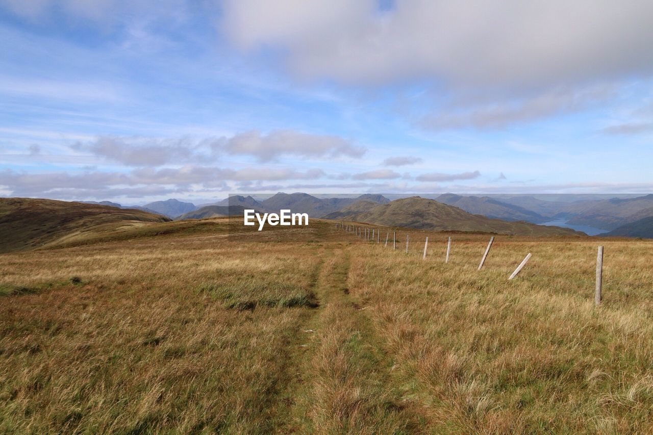 Scenic view of field against cloudy sky