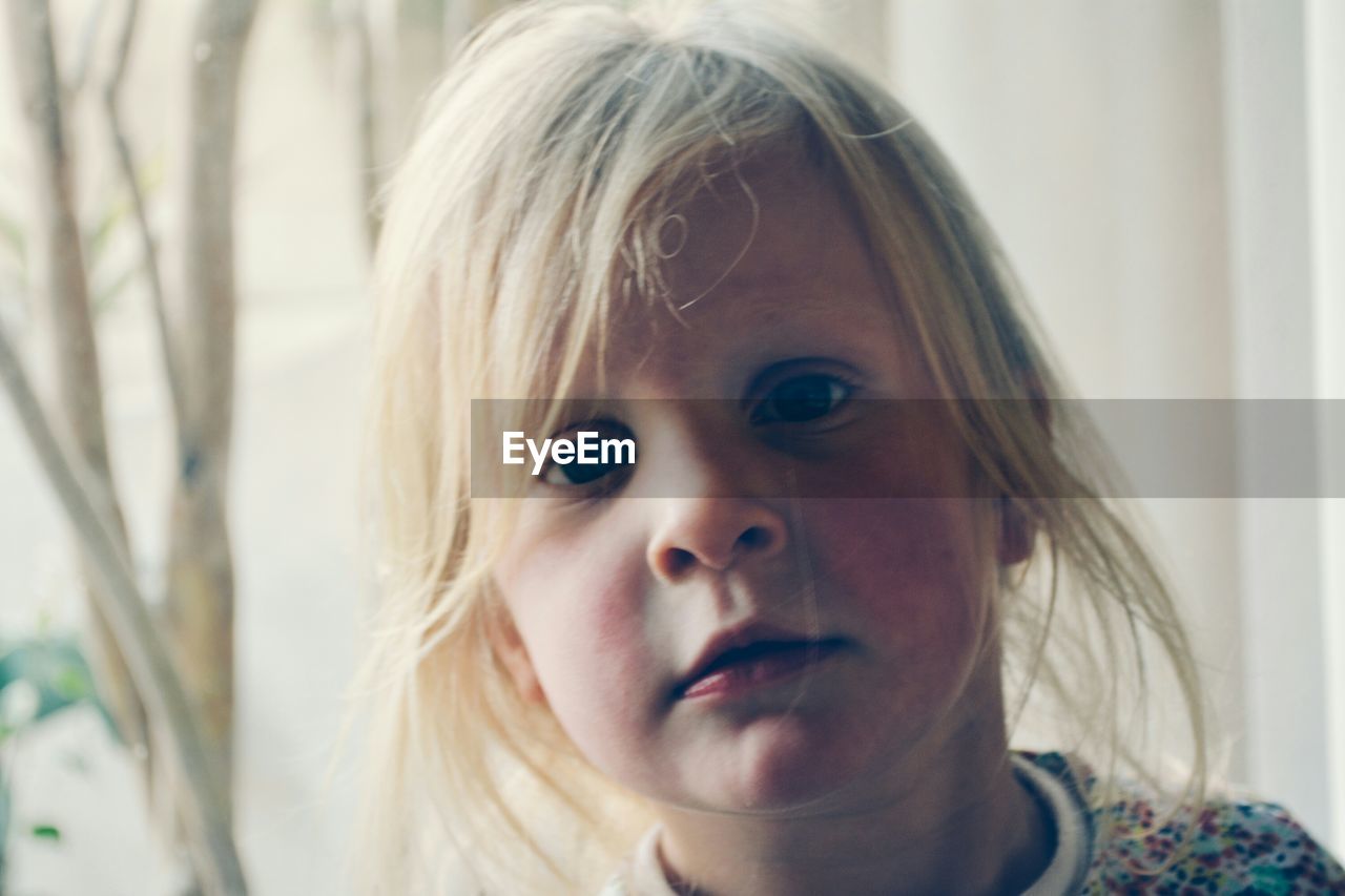 Close-up portrait of cute girl at home