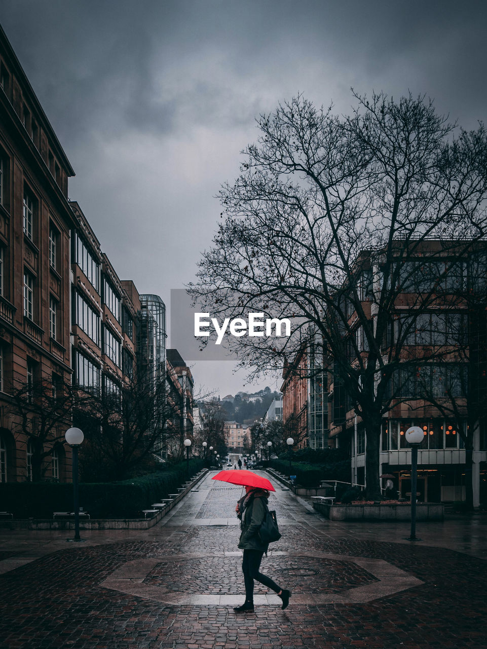 MAN WALKING IN CITY AGAINST SKY