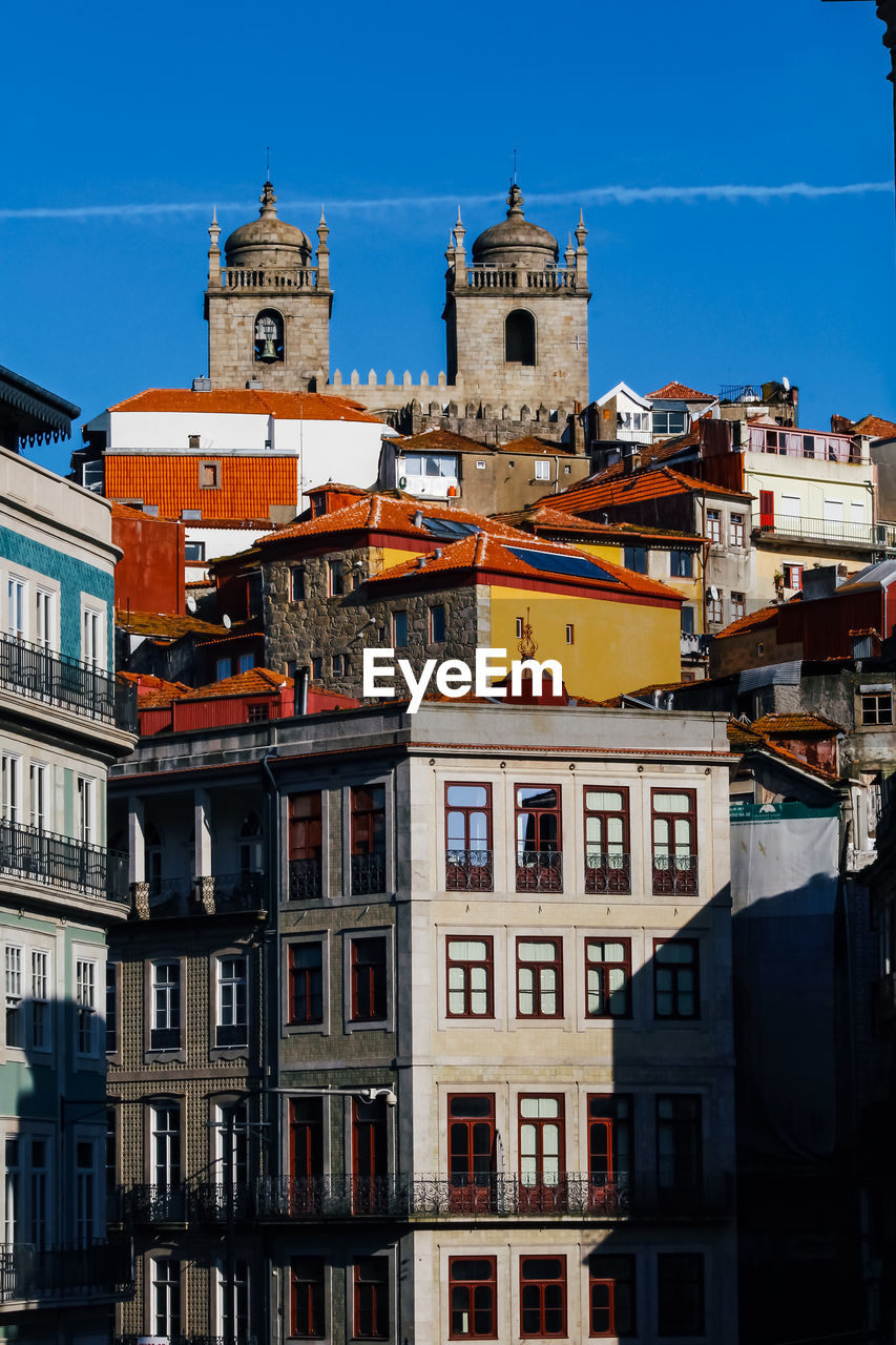 Buildings in town against blue sky