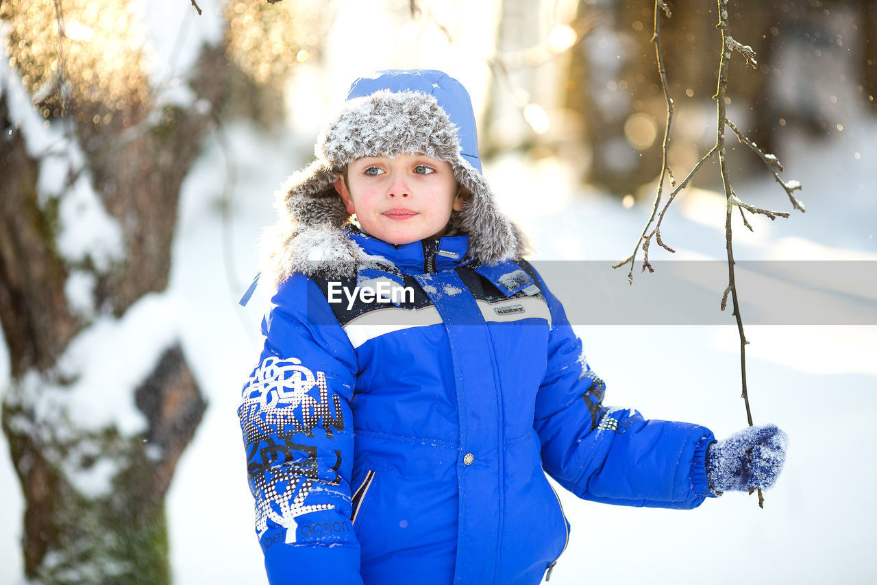 Portrait of a boy 6 years old in warm clothes in winter