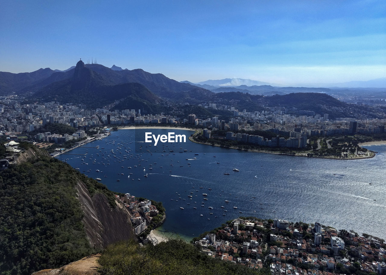 High angle view of city by sea against sky