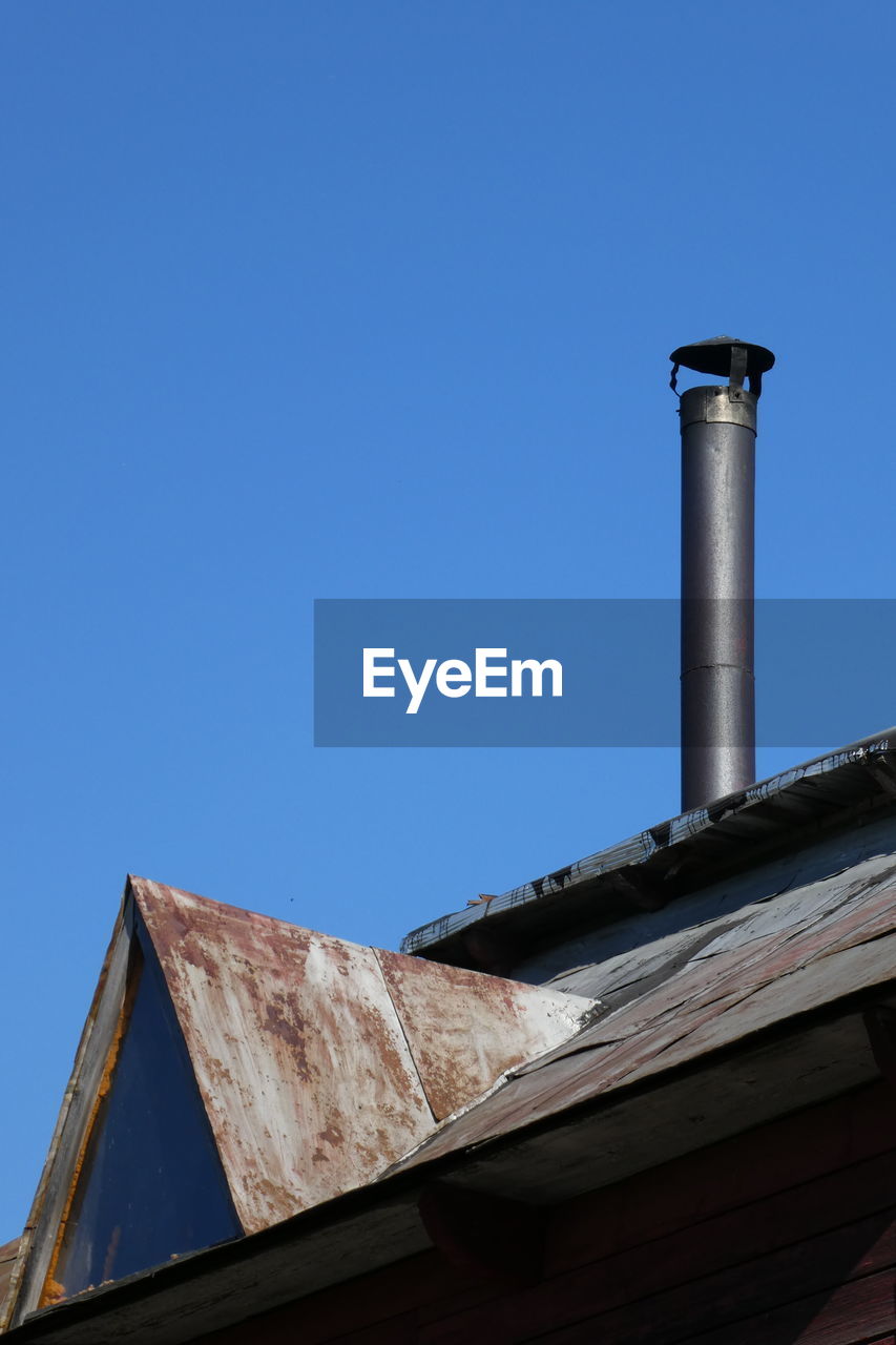 LOW ANGLE VIEW OF SMOKE STACK AGAINST BLUE SKY