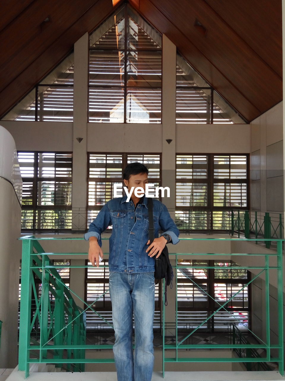 FULL LENGTH OF YOUNG MAN LOOKING AT WINDOW