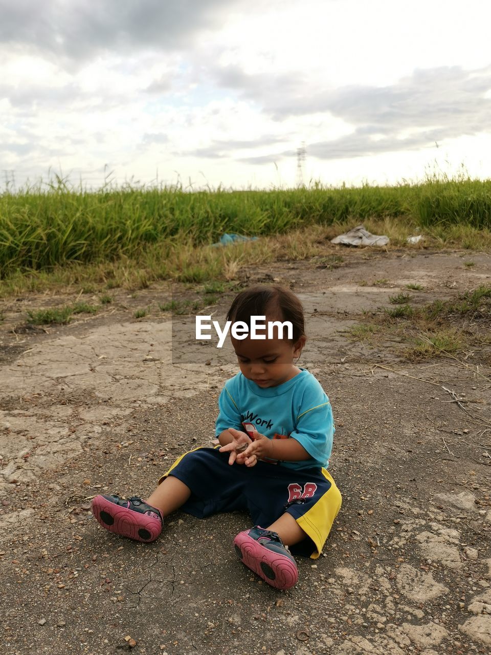 FULL LENGTH OF BOY ON FIELD AGAINST SKY