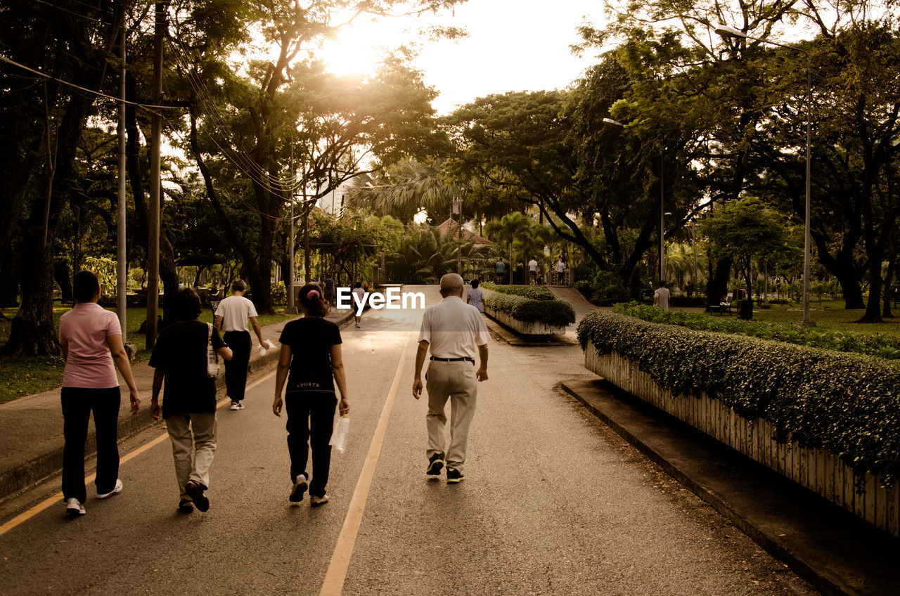 People walking on country road along landscape