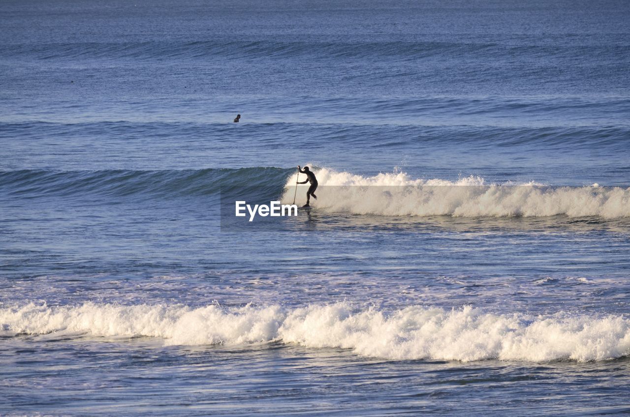 Man surfing on wave in sea