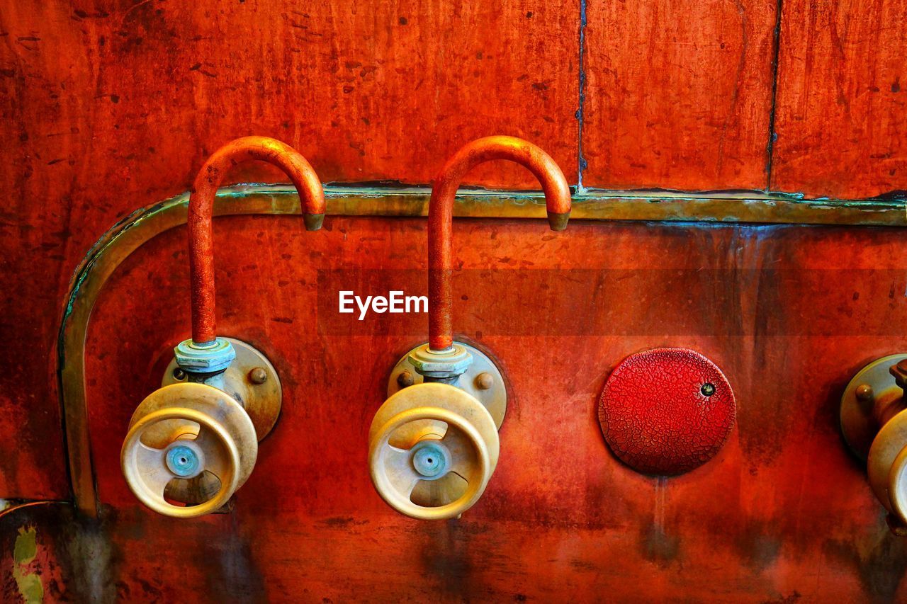 CLOSE-UP OF ELECTRIC LAMP HANGING ON RED METAL