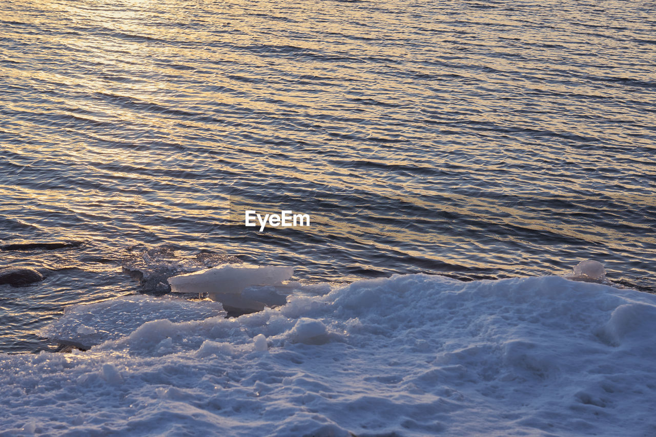 HIGH ANGLE VIEW OF RIVER FLOWING THROUGH SNOW