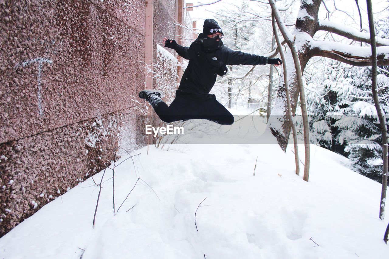 Person kicking in the air above snow ground