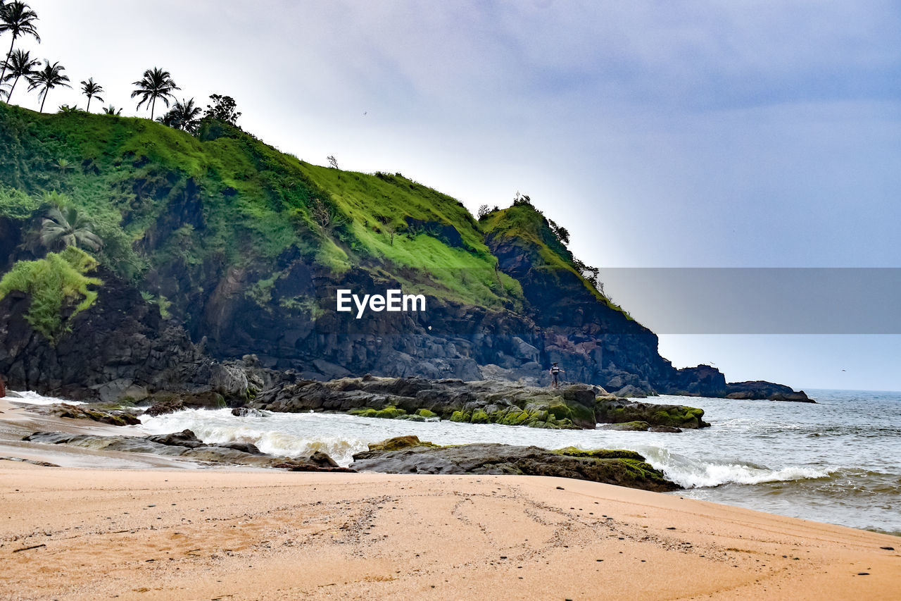 Scenic view of sea and mountains against sky