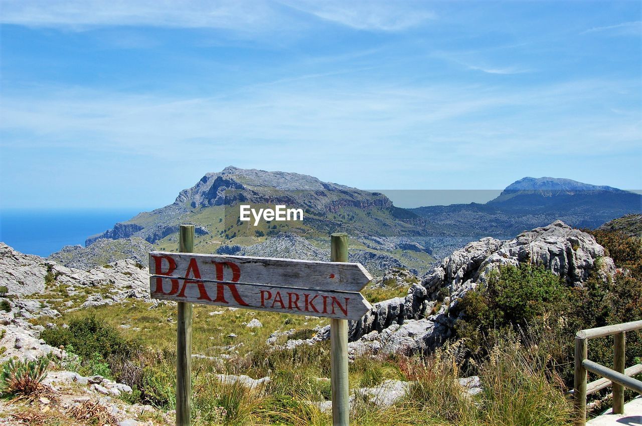 View of signboard against mountain range