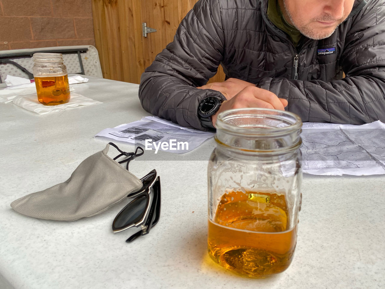 MIDSECTION OF MAN WITH DRINK SITTING IN GLASS