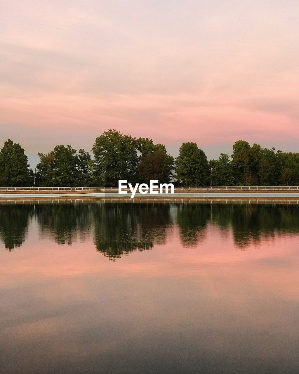 SCENIC VIEW OF CALM LAKE AT SUNSET