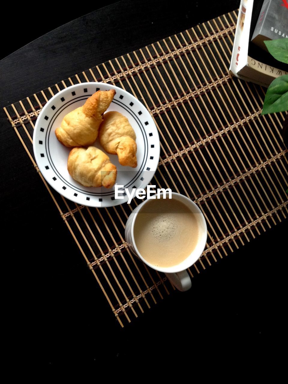 High angle view of coffee and croissant on table