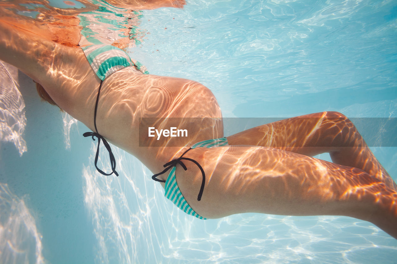 Low section of woman swimming in sea