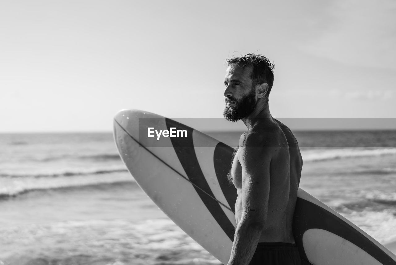 Man looking at sea shore against sky