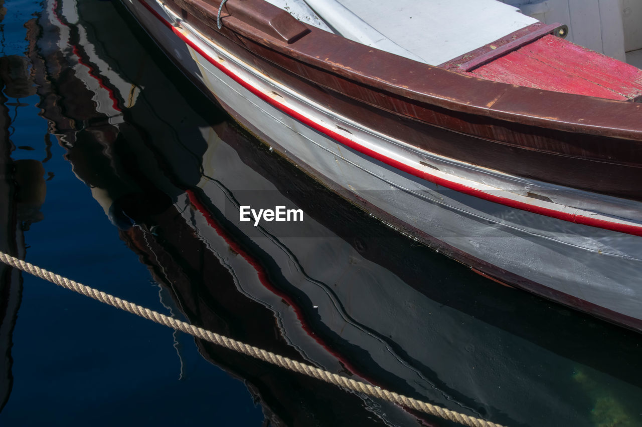 HIGH ANGLE VIEW OF FISHING BOAT MOORED AT LAKE