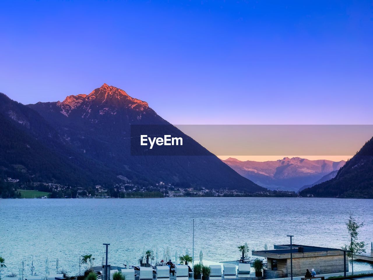 Scenic view of lake and mountains against sky during sunset