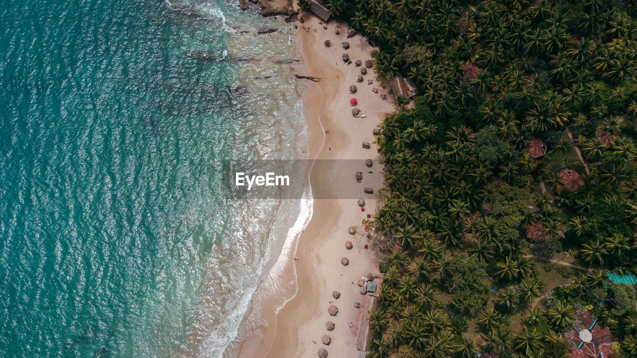 Tropical coast, ocean and waves crashing against rocks, drone shot, exotic landscape.