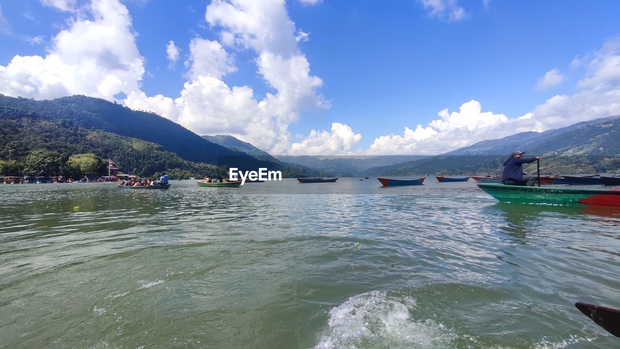 water, mountain, nautical vessel, sky, transportation, cloud, nature, scenics - nature, boating, vehicle, boat, mode of transportation, mountain range, travel, beauty in nature, sea, travel destinations, day, landscape, environment, land, blue, outdoors, tourism, vacation, holiday, trip, tranquility, no people, beach, tranquil scene, bay, watercraft, kayak, architecture, sunlight, ship