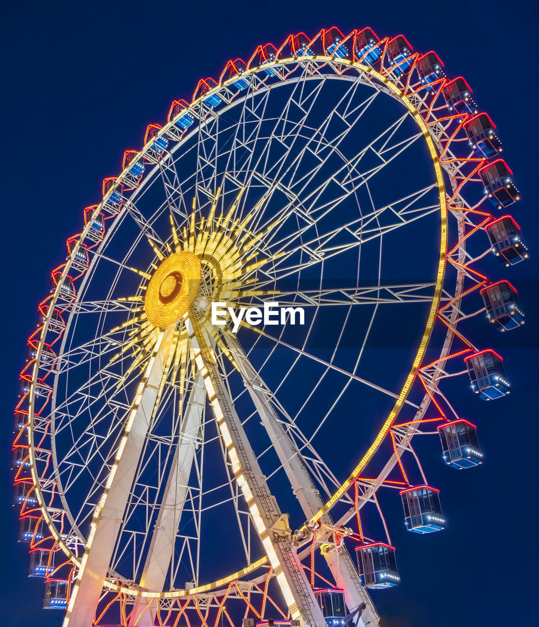 Low angle view of illuminated ferris wheel against sky at night