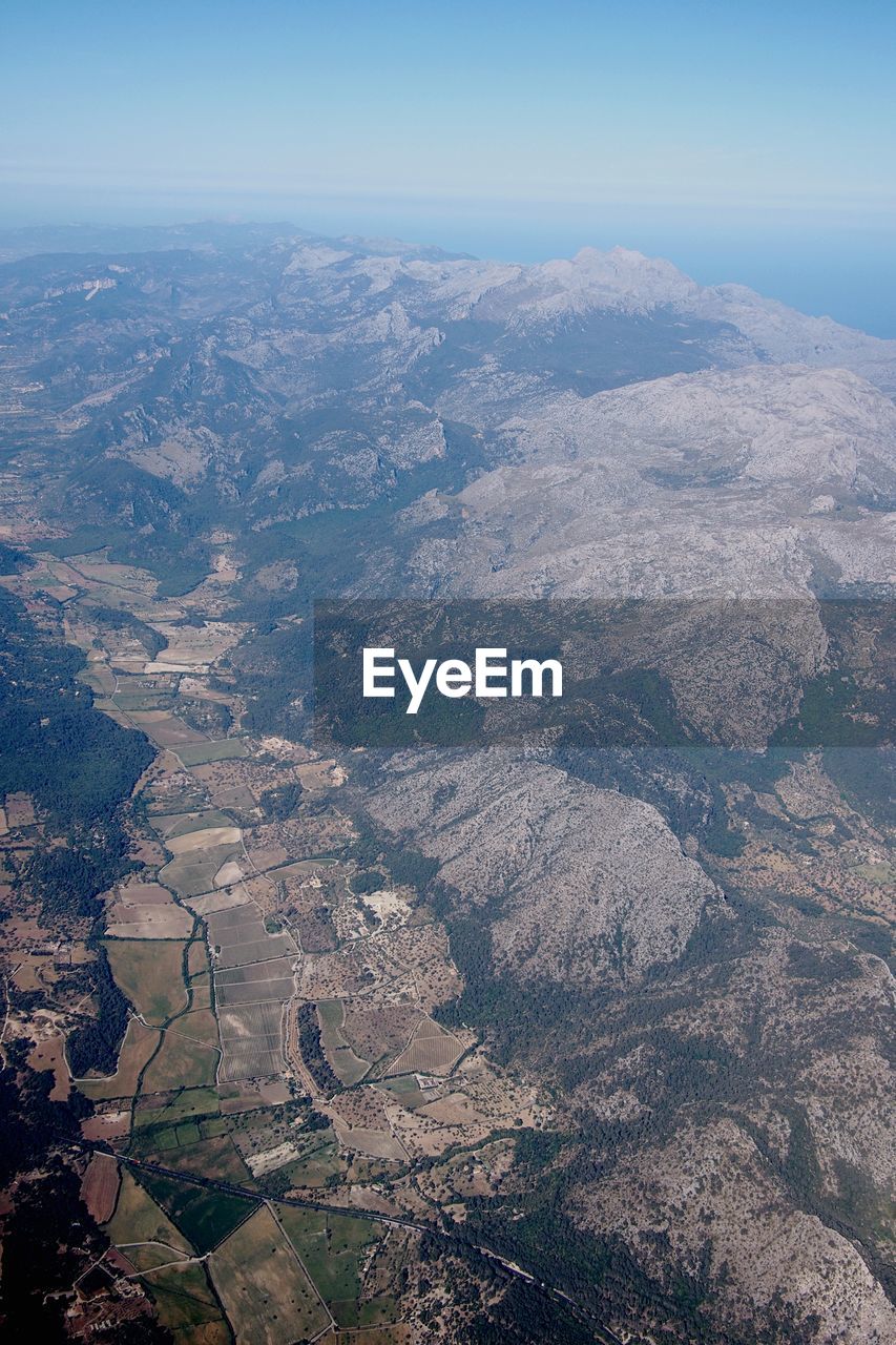 AERIAL VIEW OF LANDSCAPE WITH MOUNTAIN RANGE IN BACKGROUND