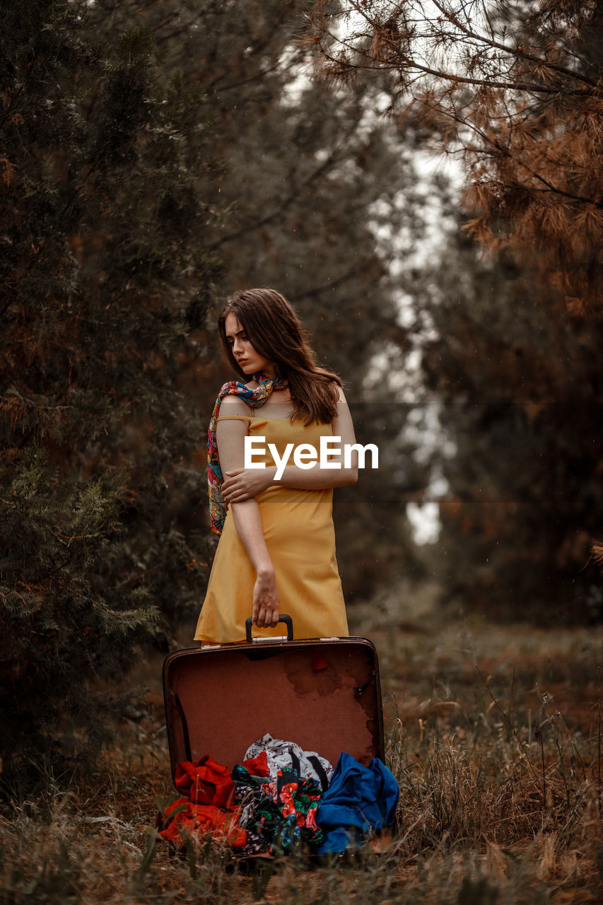 YOUNG WOMAN WEARING SUNGLASSES ON TREE