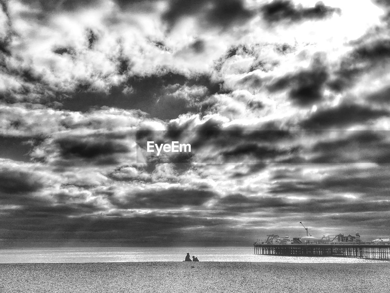 Scenic view of beach against cloudy sky