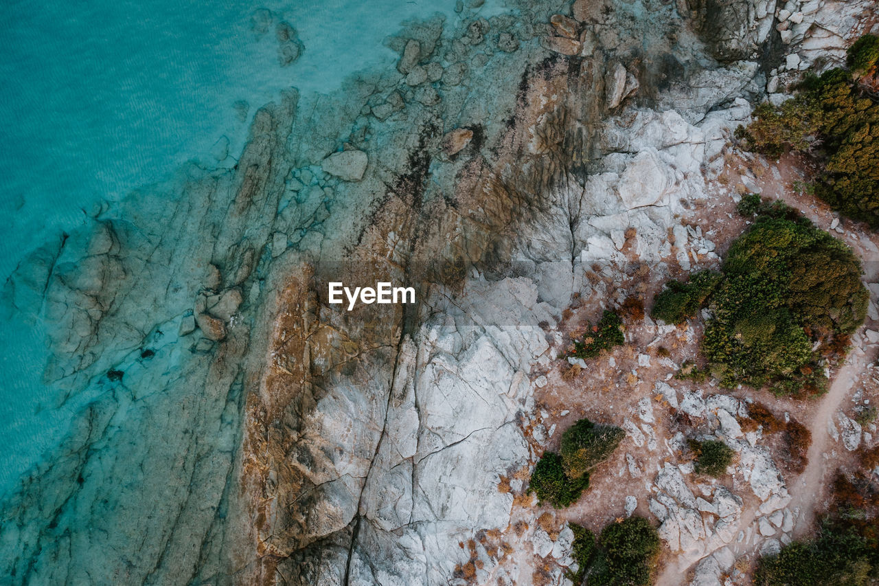 Aerial high angle view of rocks on sea