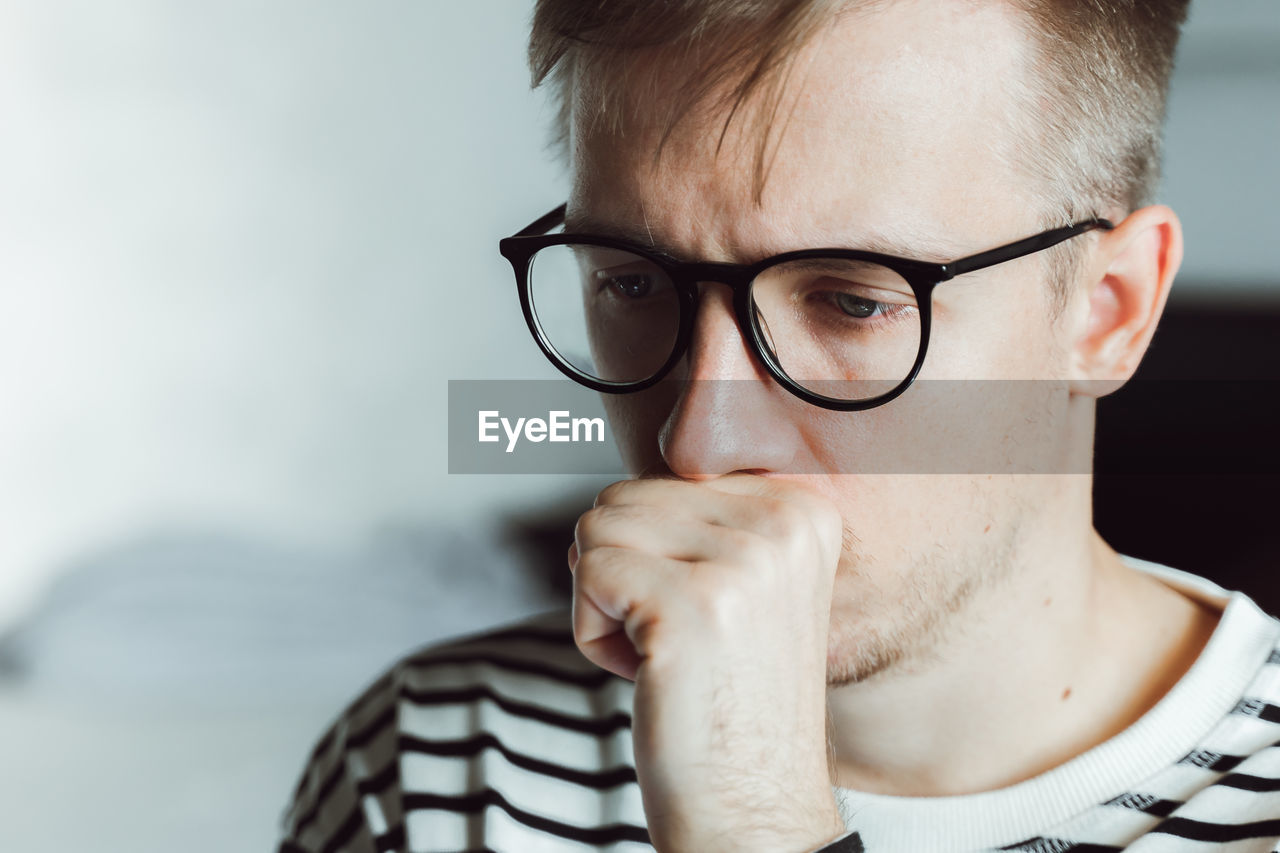 CLOSE-UP PORTRAIT OF A MAN WEARING EYEGLASSES