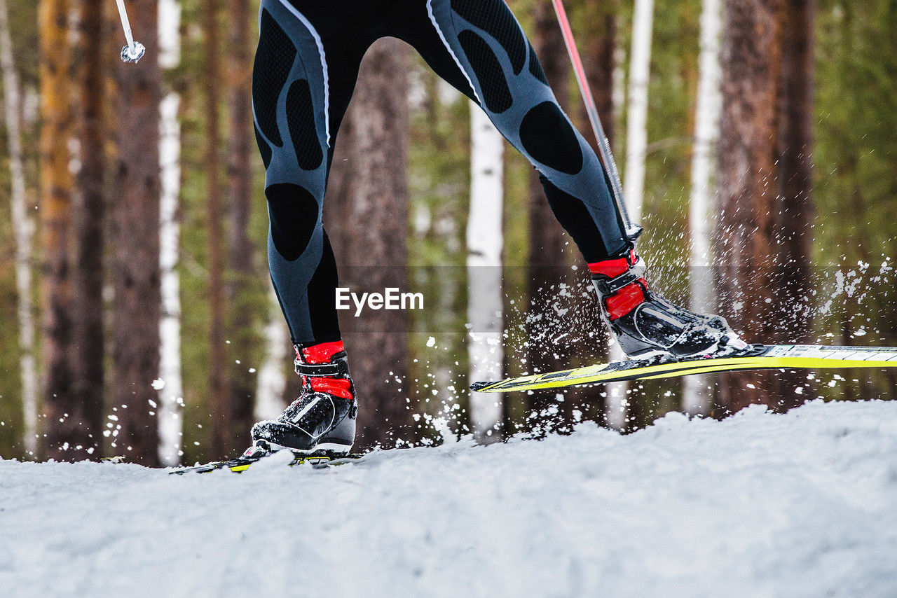 sports, human leg, winter, snow, low section, leisure activity, vitality, cold temperature, lifestyles, motion, nature, one person, adult, footwear, clothing, sports clothing, exercising, winter sports, activity, limb, skiing, human limb, day, athlete, recreation, land, outdoors, forest, tree, shoe, mountain, competition, speed, men, young adult, extreme sports, skill, sports training, running
