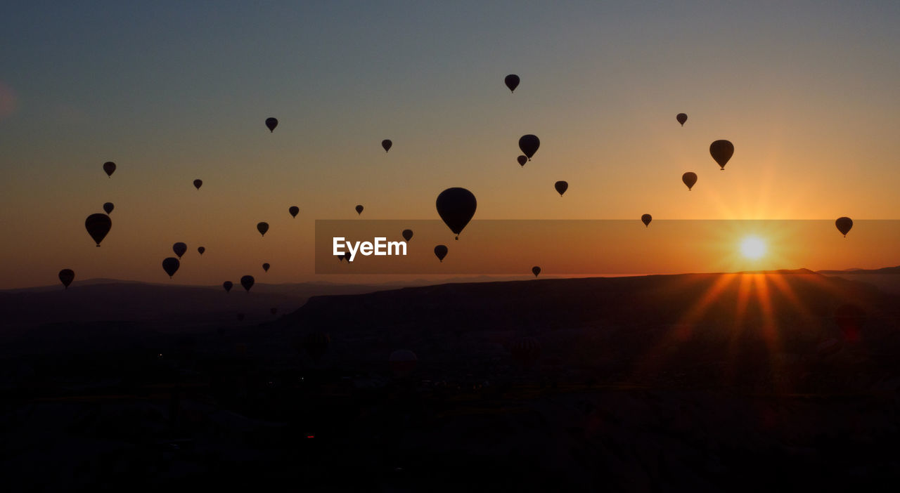 SILHOUETTE OF HOT AIR BALLOONS IN SKY DURING SUNSET